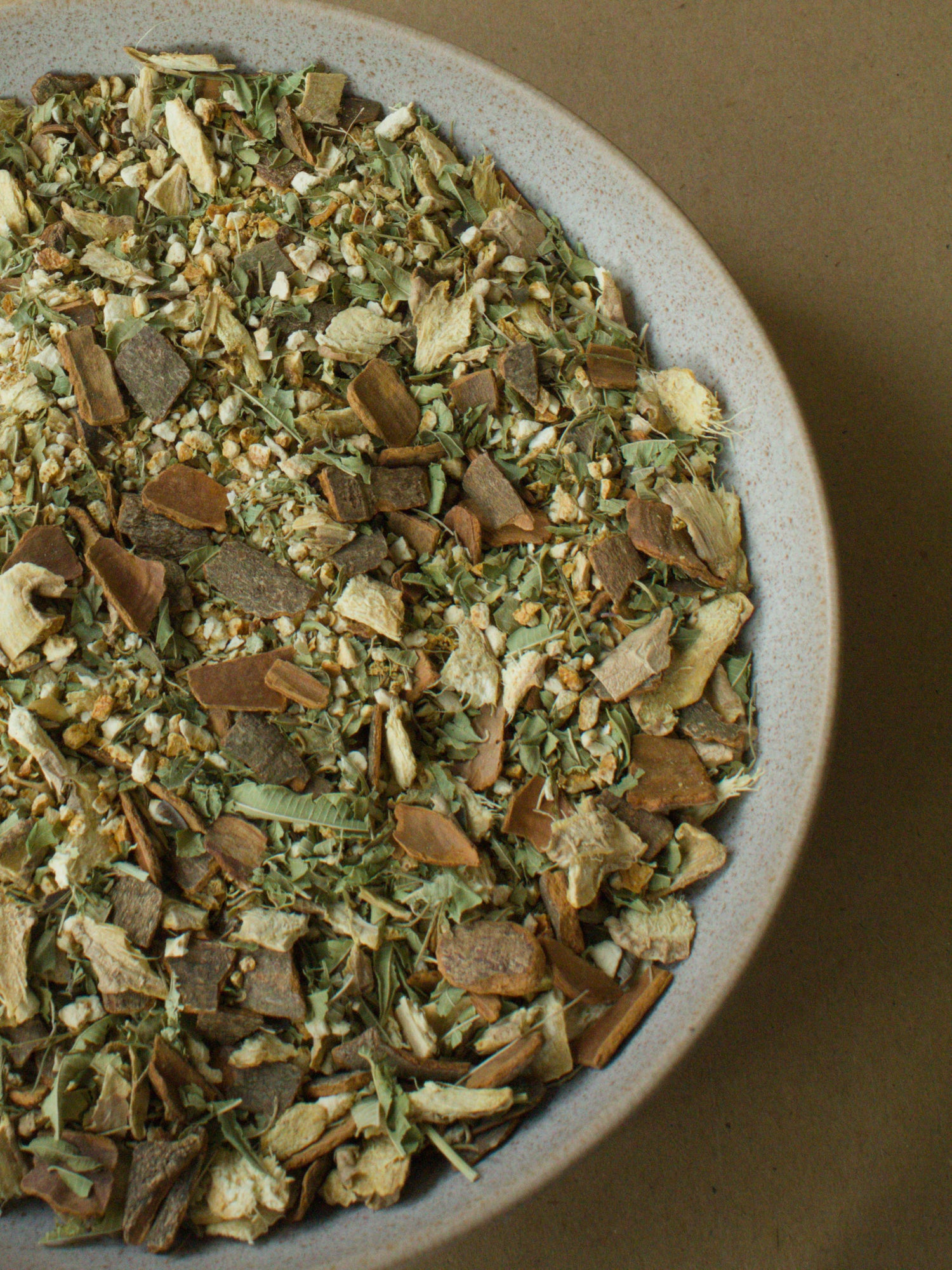 Soul Warmer loose-leaf blend — orange peel, ginger, cinnamon shards and lemon verbena in a stoneware bowl.